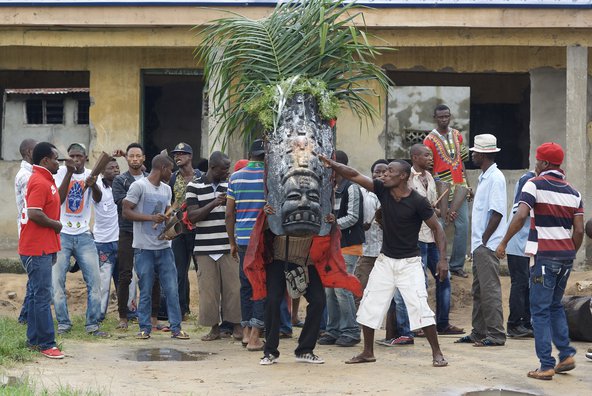 A group of young men with musical instruments perform in an agaba masquerade