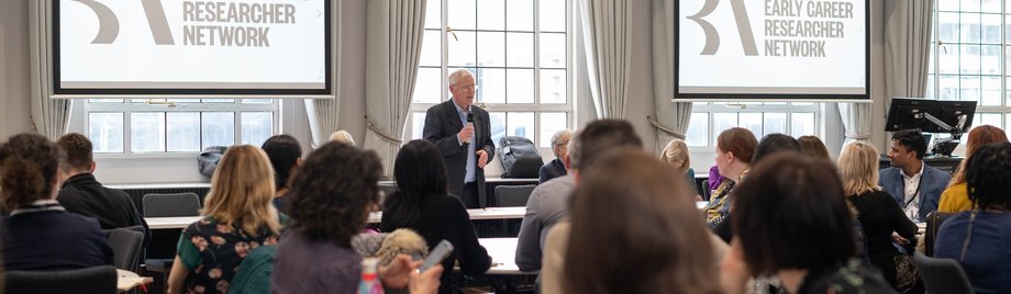 A room of ECR Network members listening to a talk by a British Academy Fellow